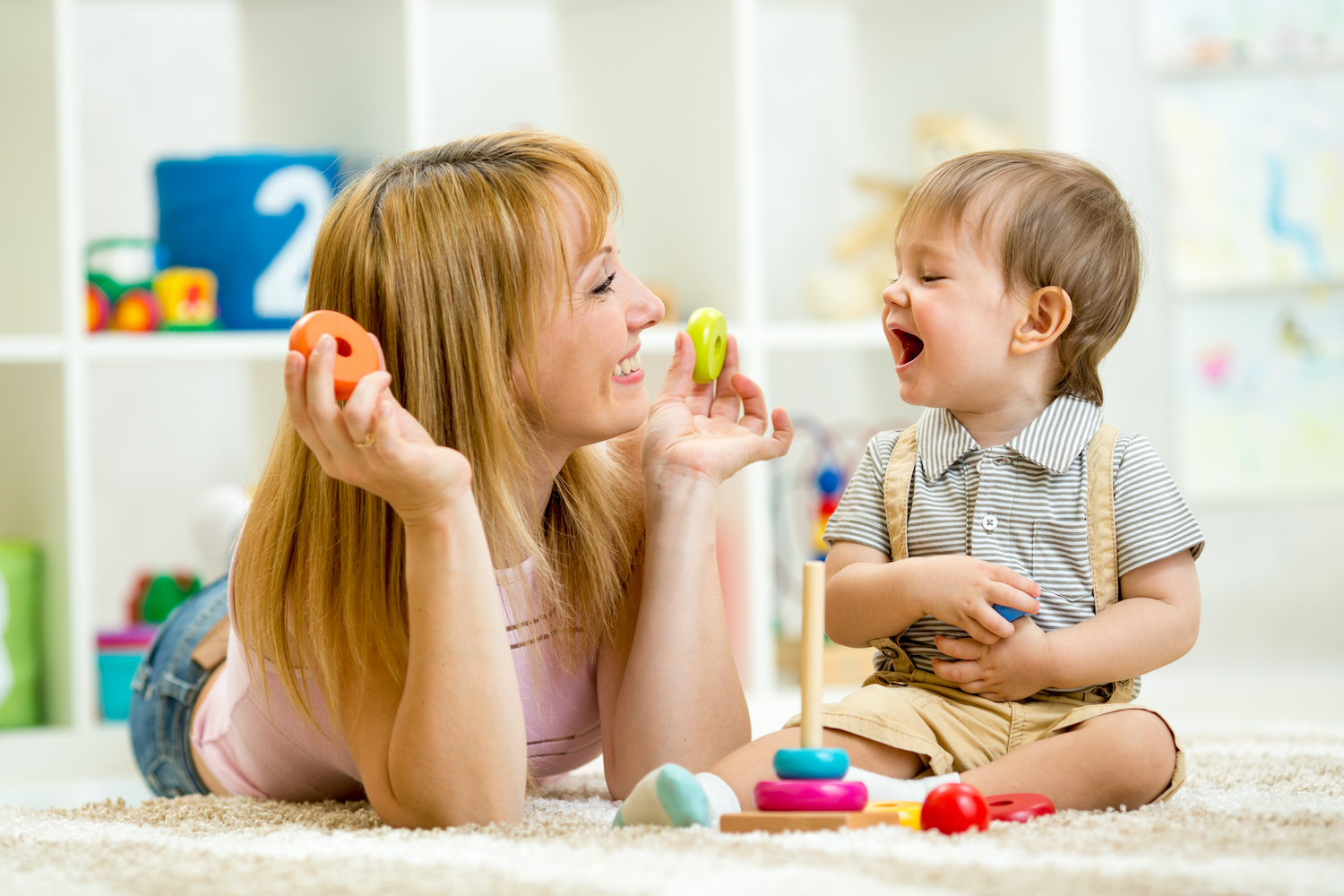 parent and baby boy playing together at home